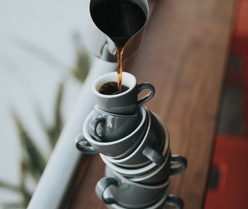 person holding gray stainless steel pitcher bside window