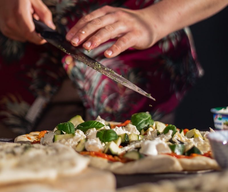 person holding knife slicing vegetable