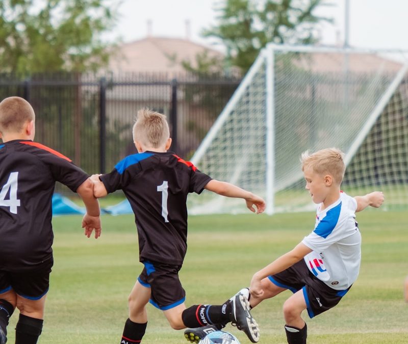 2 men playing soccer during daytime