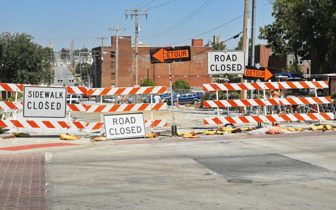 a road closed sign sitting on the side of a road