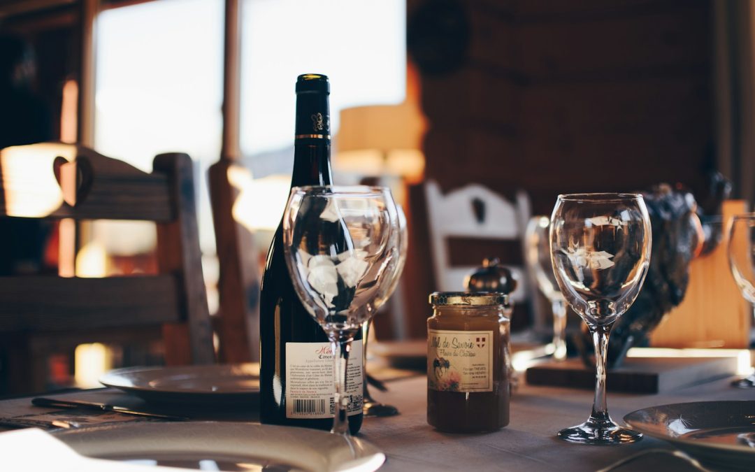 closeup photo of two empty wine glasses beside wine bottle